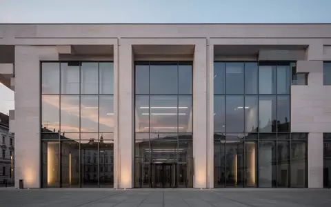 Modernes Verwaltungsgebäude in Wien bei Dämmerung mit schlichter Steinfassade und großen, leeren Fensterfronten. - Foto: über boerse-global.de