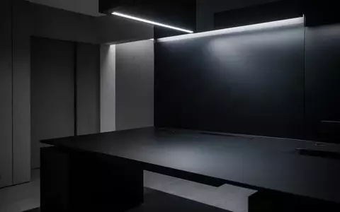 Ein minimalistischer, leerer Schreibtisch in einem modern beleuchteten Raum mit schlichten architektonischen Linien. - Foto: über boerse-global.de