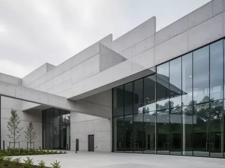 Moderne Architektur eines Klinikgebäudes mit klaren Linien und Glasfassaden vor einem bewölkten Himmel. - Foto: über boerse-global.de
