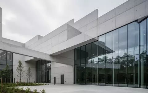 Moderne Architektur eines Klinikgebäudes mit klaren Linien und Glasfassaden vor einem bewölkten Himmel. - Foto: über boerse-global.de
