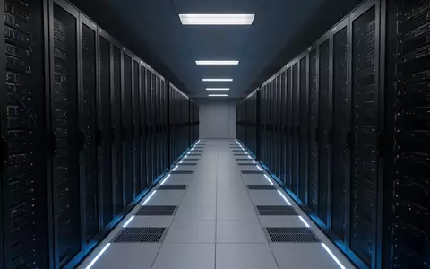 Eine lange, minimalistisch gestaltete Serverraum-Reihe in kühlem, blauem Licht ohne Personen oder technische Anzeigen. - Foto: über boerse-global.de