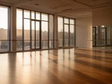 Ein heller, minimalistischer Tanzraum mit Parkettboden und großen Fenstern, durch die natürliches Licht einfällt. - Foto: über boerse-global.de