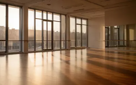 Ein heller, minimalistischer Tanzraum mit Parkettboden und großen Fenstern, durch die natürliches Licht einfällt. - Foto: über boerse-global.de