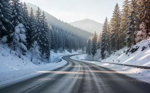 Eine kurvenreiche Passstraße in einer verschneiten Gebirgslandschaft an einem klaren Wintermorgen. - Foto: über boerse-global.de