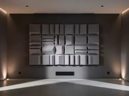 Ein minimalistischer Medienraum mit einem akustischen Diffusor-Paneel an einer dunklen Wand. - Foto: über boerse-global.de