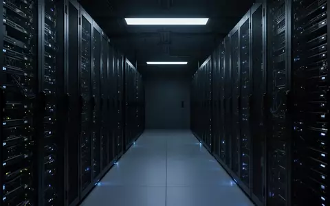 Ein dunkler, minimalistischer Serverraum mit leuchtenden Server-Racks in einer industriellen Umgebung. - Foto: über boerse-global.de