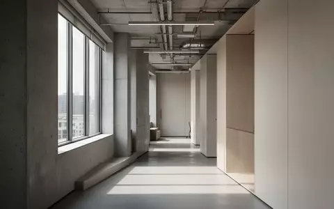 Ein minimalistischer, moderner Büroflur mit klaren architektonischen Linien und hellem Tageslicht. - Foto: über boerse-global.de