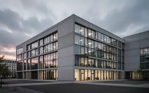 Ein modernes, minimalistisches Bürogebäude in Berlin bei bewölktem Dämmerlicht. - Foto: über boerse-global.de