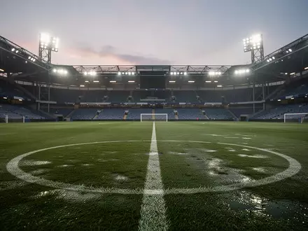Ein leerer, professioneller Fußballplatz bei Dämmerung unter Flutlicht. - Foto: über boerse-global.de