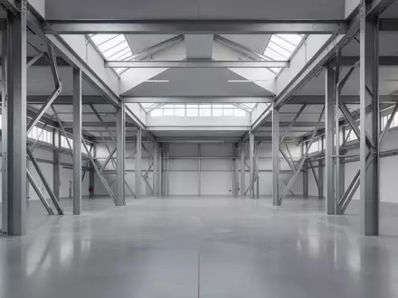 Ein minimalistischer, moderner Industrieraum mit polierten Betonböden und klaren architektonischen Linien bei natürlichem Lichteinfall. - Foto: über boerse-global.de
