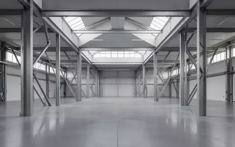 Ein minimalistischer, moderner Industrieraum mit polierten Betonböden und klaren architektonischen Linien bei natürlichem Lichteinfall. - Foto: über boerse-global.de