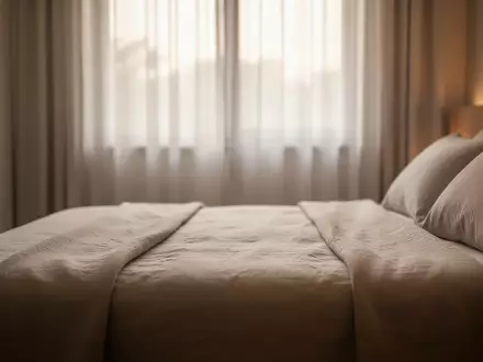 Ein minimalistisch gestaltetes Schlafzimmer mit neutraler Bettwäsche in sanftem Morgenlicht. - Foto: über boerse-global.de
