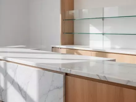 Ein minimalistisch gestalteter, heller Tresenbereich in einer modernen Apotheke ohne Personen oder technische Geräte. - Foto: über boerse-global.de