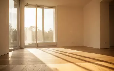 Sonnenlicht in einem hellen, minimalistischen Innenraum mit Schattenwurf auf einem Holzboden. - Foto: über boerse-global.de