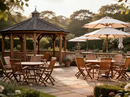 Ein sonniger, leerer Terrassenbereich eines Seniorenpflegeheims mit Gartenmöbeln, Pavillon und Sonnenschirmen. - Foto: über boerse-global.de