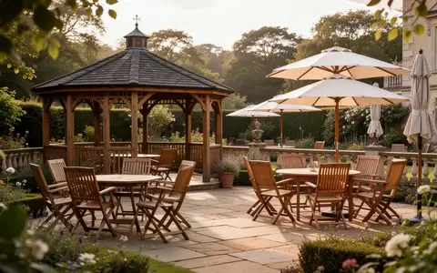 Ein sonniger, leerer Terrassenbereich eines Seniorenpflegeheims mit Gartenmöbeln, Pavillon und Sonnenschirmen. - Foto: über boerse-global.de