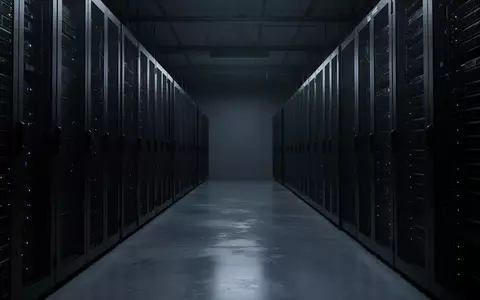 Dunkler, minimalistischer Serverraum mit metallischen Server-Racks in kühlem, blauem Licht. - Foto: über boerse-global.de