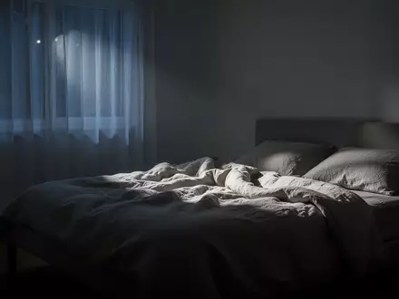 Ein ruhig beleuchtetes, minimalistisches Schlafzimmer in der Nacht, das eine Atmosphäre der Erholung und Stille vermittelt. - Foto: über boerse-global.de