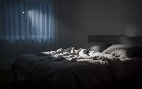 Ein ruhig beleuchtetes, minimalistisches Schlafzimmer in der Nacht, das eine Atmosphäre der Erholung und Stille vermittelt. - Foto: über boerse-global.de