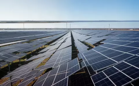 Weitläufige Solarparkanlage mit zahlreichen Photovoltaik-Modulen unter einem klaren Himmel. - Foto: über boerse-global.de
