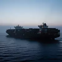 Ein großes Containerschiff auf hoher See während der Dämmerung, das die Weite und Komplexität der maritimen Logistik verdeutlicht. - Foto: über boerse-global.de
