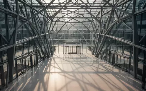 Ein modernes, architektonisch gestaltetes Atrium mit geometrischen Stahlstrukturen und klaren Linien. - Foto: über boerse-global.de