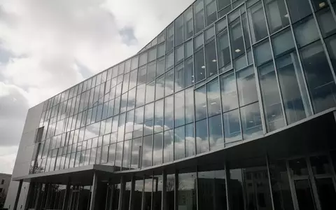 Moderne Glasfassade eines Verwaltungsgebäudes bei bewölktem Himmel. - Foto: über boerse-global.de
