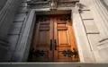 Schwere, kunstvolle Holztür eines Regierungsgebäudes in einer minimalistischen Architekturaufnahme. - Foto: über boerse-global.de