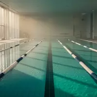 Ein helles, ruhiges Schwimmbecken in einer minimalistischen Architektur mit reflektierendem Wasser. - Foto: über boerse-global.de