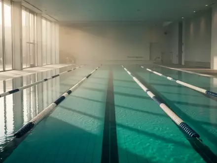Ein helles, ruhiges Schwimmbecken in einer minimalistischen Architektur mit reflektierendem Wasser. - Foto: über boerse-global.de