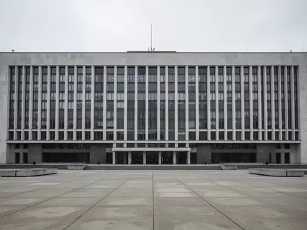Die Fassade eines modernen Regierungsgebäudes in Warschau an einem bewölkten Tag, davor ein weiter, leerer Platz. - Foto: über boerse-global.de