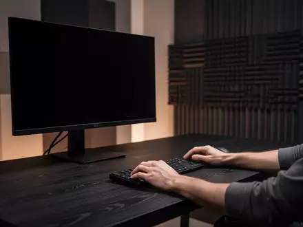 Ein minimalistischer, professioneller Videoschnitt-Arbeitsplatz mit dunkler Holzoberfläche und ausgeschaltetem Monitor. - Foto: über boerse-global.de