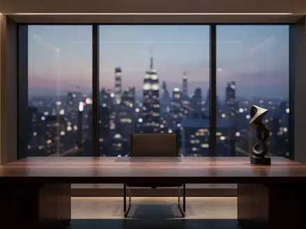 Ein minimalistischer, moderner Arbeitsplatz in einem Büro bei Dämmerung mit Blick auf eine nächtliche Stadt. - Foto: über boerse-global.de