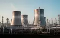 Industrielle Chemieanlage mit großen Kühltürmen und Rohrleitungssystemen vor klarem Himmel. - Foto: über boerse-global.de