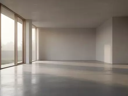 Ein minimalistischer, moderner Innenraum mit hellem Tageslicht, das auf einen leeren Betonboden fällt. - Foto: über boerse-global.de