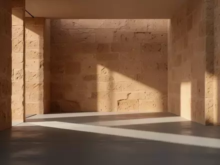 Ein minimalistischer, sonnendurchfluteter Innenraum mit strukturierten Steinwänden und klaren architektonischen Linien. - Foto: über boerse-global.de