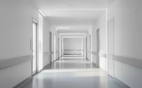 Ein heller, leerer Flur in einem modernen Krankenhausgebäude mit klaren Linien und indirektem Tageslicht. - Foto: über boerse-global.de