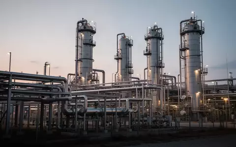 Industrielle Chemieanlage mit komplexem Rohrsystem und Destillationskolonnen bei Dämmerung. - Foto: über boerse-global.de