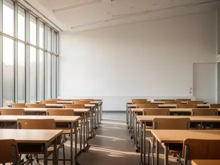 Ein heller, moderner Hörsaal mit leeren Holztischen und Stühlen in einer Pädagogischen Hochschule. - Foto: über boerse-global.de