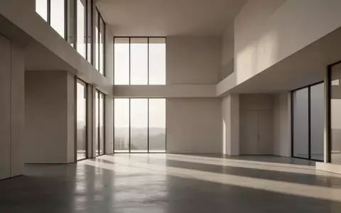 Ein minimalistischer, architektonischer Innenraum mit klaren Linien und natürlichem Lichteinfall auf einem Betonboden. - Foto: über boerse-global.de