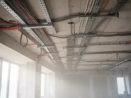 Baustelle mit freiliegenden Elektrokabeltrassen und Betonarchitektur in einem zu modernisierenden Verwaltungsgebäude. - Foto: über boerse-global.de