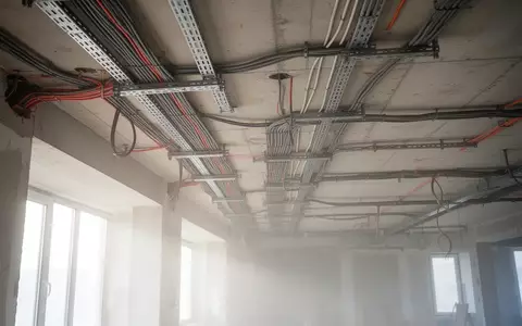 Baustelle mit freiliegenden Elektrokabeltrassen und Betonarchitektur in einem zu modernisierenden Verwaltungsgebäude. - Foto: über boerse-global.de