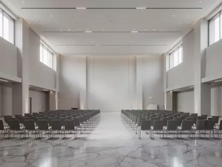 Ein moderner, leerer Konferenzsaal mit polierten Böden und einfallendem Tageslicht. - Foto: über boerse-global.de