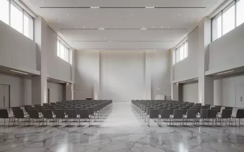 Ein moderner, leerer Konferenzsaal mit polierten Böden und einfallendem Tageslicht. - Foto: über boerse-global.de