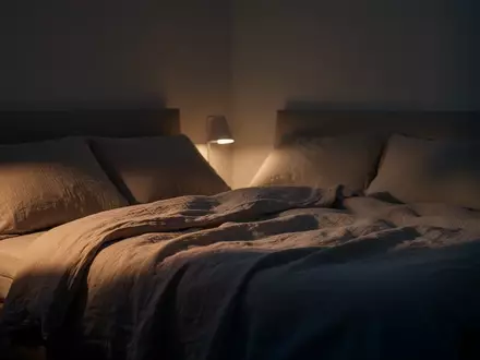 Ein minimalistisch gestaltetes, ruhig beleuchtetes Schlafzimmer in der Dämmerung, das eine Atmosphäre der Entspannung ausstrahlt. - Foto: über boerse-global.de