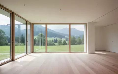 Heller, moderner Innenraum mit großen Fenstern und Blick auf eine grüne Landschaft in Oberbayern. - Foto: über boerse-global.de