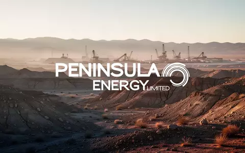 Weite, karge Wüstenlandschaft mit industrieller Infrastruktur in der Ferne bei goldenem Licht. - Foto: über boerse-global.de