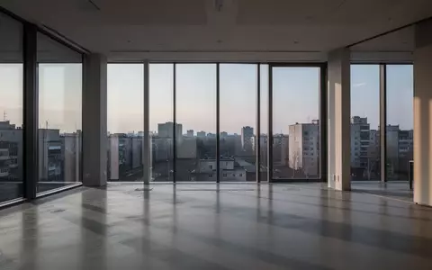 Ein leerer, minimalistischer Büroraum mit großen Fensterfronten und Blick auf eine urbane Umgebung bei Dämmerung. - Foto: über boerse-global.de