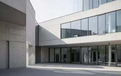 Modernes Verwaltungsgebäude mit klarer Architektur aus Glas und Beton bei Tageslicht. - Foto: über boerse-global.de
