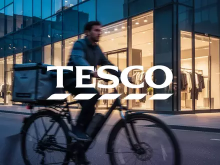 Moderne urbane Szene mit einem Lieferfahrrad vor einer beleuchteten Ladenfront, symbolisiert schnelle Logistik im Einzelhandel. - Foto: über boerse-global.de